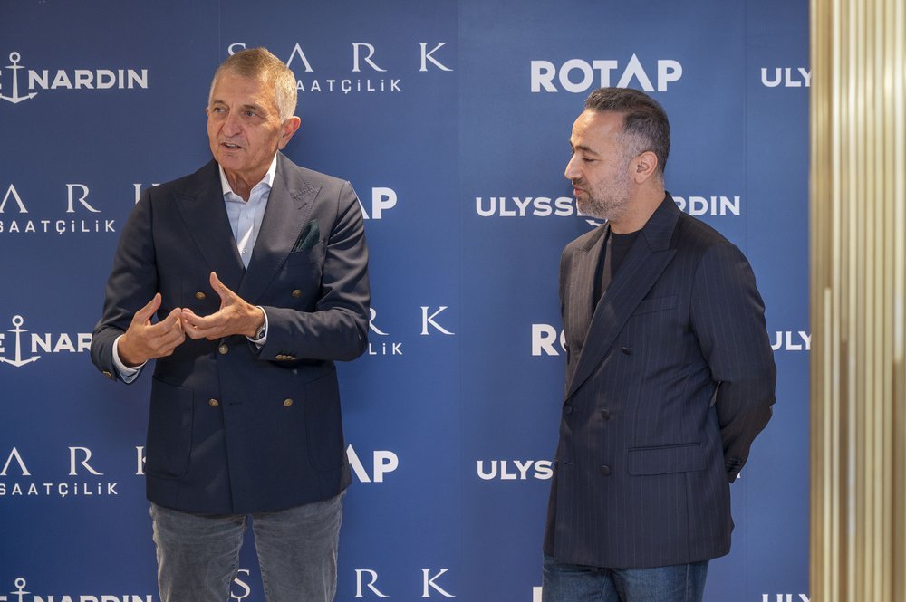 Speakers in front of the event backdrop